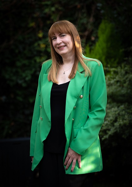 Sharon Ann in emerald green blazer in garden, 2022, photo by Stuart Robinson