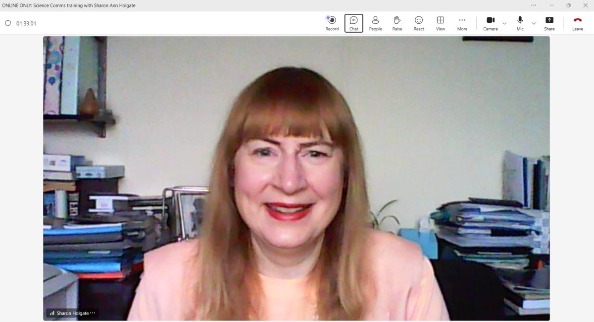Sharon Ann on the video link for the session, wearing a peach long sleeved top and peach linen sleeveless jacket, with a silver link necklace.